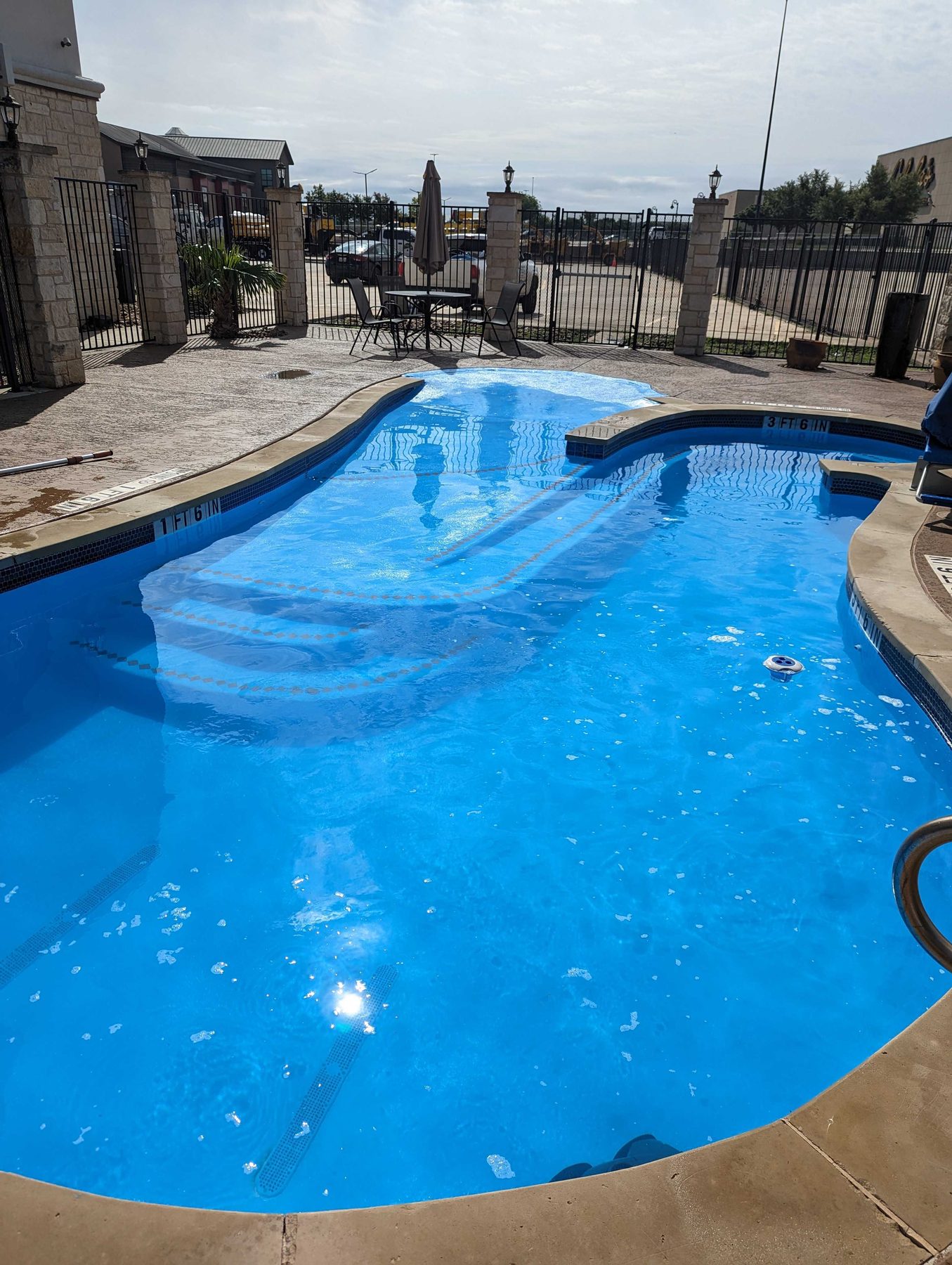The same swimming pool two days later, the water clear blue and the floor of the pool visible.